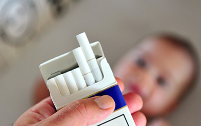 Cigarette with baby in background