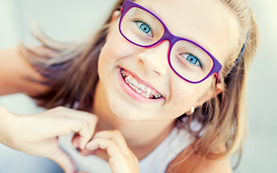 A young girl smiling with braces