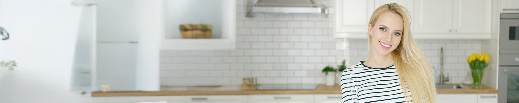 Teen smiling in a white kitchen with perfect teeth