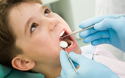 A young boy having his teeth looked at