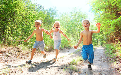Three kids running outdoors