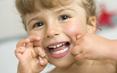 Young girl flossing her teeth
