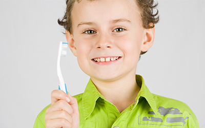 A young boy holding a toothbrush