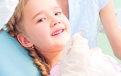 Young girl smiling in a dental chair